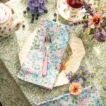 Place setting with floral napkin and tablecloth.