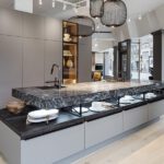 Showroom display with gray cabinets and dark stone countertop