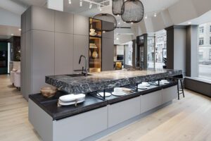 Showroom display with gray cabinets and dark stone countertop