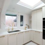 Kitchensink with large kitchen window and sky light above.