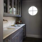 Butlers pantry with gray paint and a round window