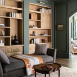 Home library with a mix of painted cabinetry and oak shelving