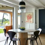 Dining area with a round pedestal table and four black chairs