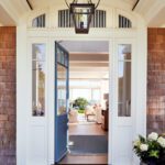 Traditional front entry of a Shingle style home with white trim and a blue door