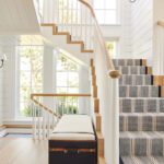 Stairway in a coastal home with a blue and white stair runner