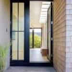 Entry with black painted doors and a shingled exteriors