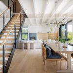 Great room of a contemporary coastal home with a floating staircase