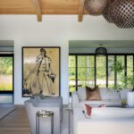 Living room with neutral furnishings a large contemporary art
