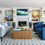 Living room with patterned rug, gray couch, and blue chairs