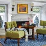 Seating area in front of a fireplace with two green chairs