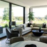 Living room with large sectional and floor to ceiling windows