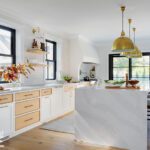Kitchen with white and oak cabinetry and a large marble-clad island.