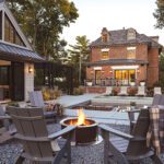 Back yard with a pool house, rectangular pool, and fire pit.