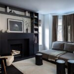 Cozy den with contemporary furnishings and a large black fireplace.