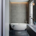Primary bedroom witha large freestanding bath tub and a shower cascading from the ceiling