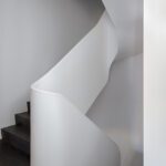 Historic home with a contemporary curving plaster staircase.