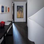 Second floor with dark white oak flooring and a curving plaster staircase.