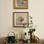 A bar cart with two still life paintings above.