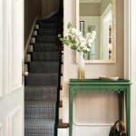 Small entryway with green table and a large rectangular mirror
