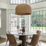 Round pedestal dining table with a large rattan chandelier