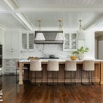 Large white kitchen with a white oak island