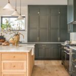 Kitchen with moss green cabinets, a light natural wood island, and white oak flooring