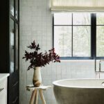 Bathtub set in front of a window with a rustic wood stand.