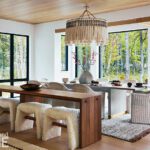 Contemporary dining room overlooking a wooded yard with a pond.