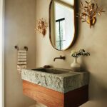 Powder room with floating walnut vanity with a custom stone sink
