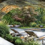 View of a pool from a space with a large stone archway
