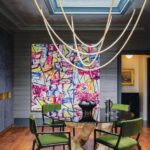 Dining room with a sculptural light and green velvet chairs