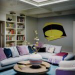 Family room with a large sectional couch, modern artwork, and bookcases
