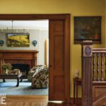 Entryway of a historic home with dark woodwork and yellow walls