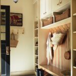 Mudroom with built in cabinetry, baskets, and large hooks