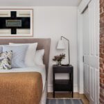 Serene lower-level design inspired by Cape Cod, featuring subtle blue accents that brighten the space and reflect the couple’s love for the coastal destination. The soothing palette enhances the primary bedroom, creating a calming and inviting retreat.