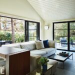 Bright and airy family room with large windows overlooking a garden, a comfortable sectional sofa, and modern minimalist decor.