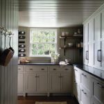 Charming walk-in pantry with white cabinetry, open shelving, a window providing natural light, and a shiplap ceiling, creating a functional and inviting space.