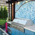 Modern rooftop grilling station with a stainless-steel grill, marble countertop, and decorative blue tile backsplash.