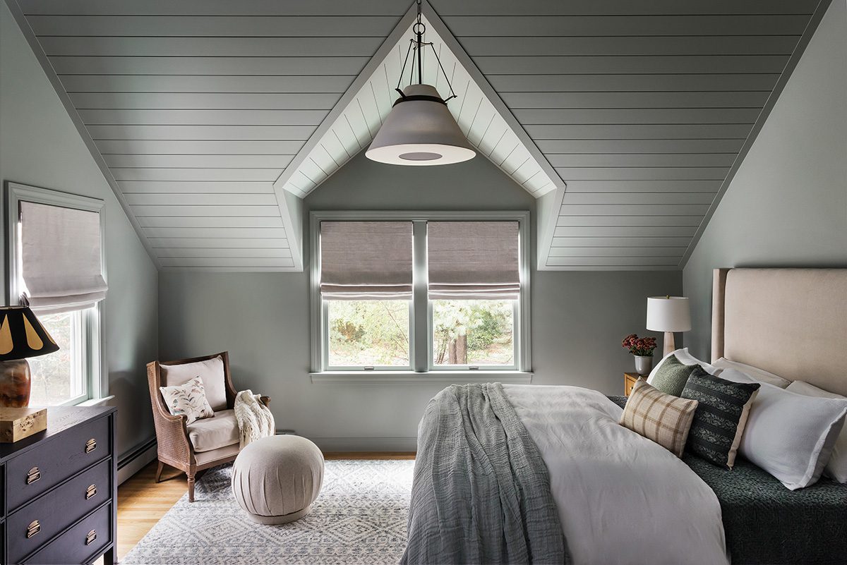 Serene attic bedroom with vaulted shiplap ceiling, sage green walls, and neutral-toned bedding and decor
