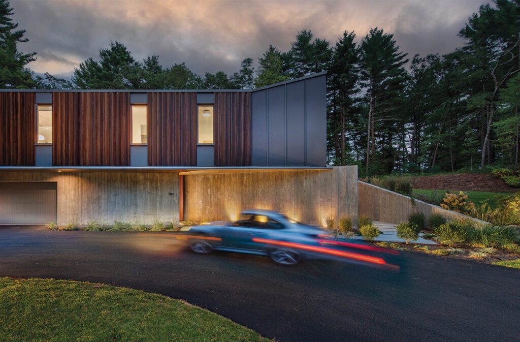 Striking modern home exterior featuring wood and concrete materials, with a sleek driveway.