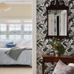 View through a floral wallpapered hallway into a serene bedroom with a large window, blue bedding, and layered coastal decor.
