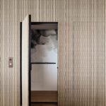 Modern residential elevator with concealed door, integrated into a striped wall design and featuring artistic black-and-white interior wall treatment.