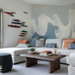 Playful family room with neutral sectional, bold abstract wall mural, and colorful fish wall decor"