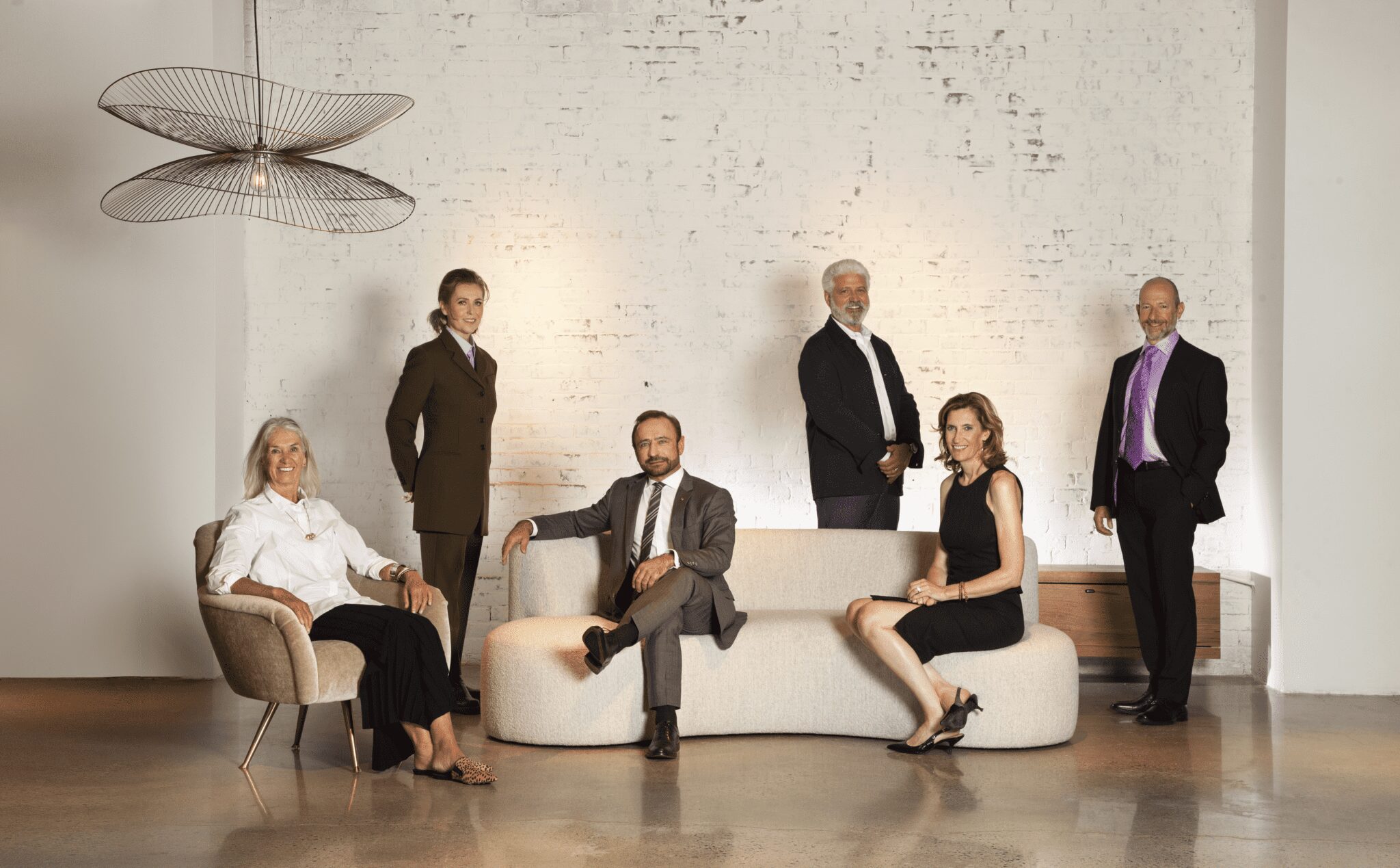 An image showing the six 2021 New England Design Hall of Fame inductees sitting and standing