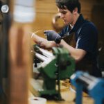 Young craftsman carefully working on a lantern fixture in the workshop at Nauset Lantern Shop.
