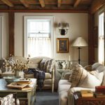 Comfortable sitting area with plush sofas, wood beams, botanical throw pillows, and warm natural light