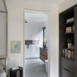 Clean-lined bathroom with white tiled walls, floating vanity, and a large walk-in shower with modern fixtures