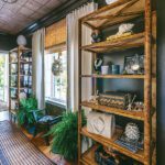 Tropical-inspired hallway with open wood shelving, curated accessories, potted ferns, and woven blinds that complement a warm, natural palette.