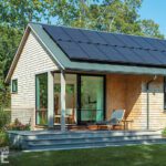 Guest suite with sliding glass doors, solar panels, and private porch, highlighting sustainable design and modern comfort.