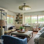 Transitional living room featuring built-in shelving, coastal wave artwork above the fireplace, and a mix of tailored and patterned seating.
